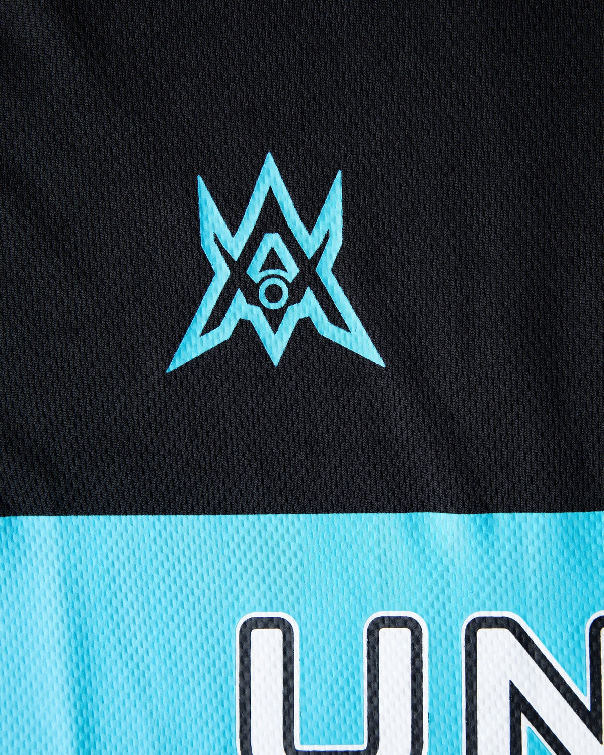 Alan Walker Unity Force Tribe Jersey print detail, cyan tribe star above the white Unity lettering on cyan