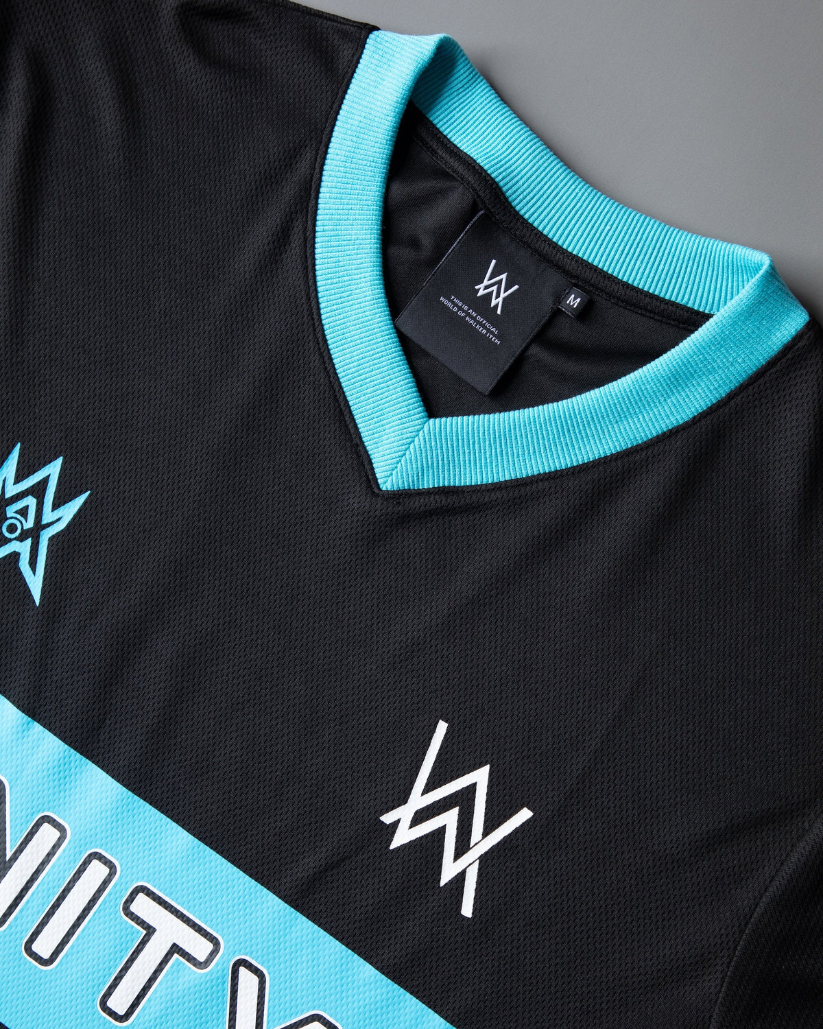 Alan Walker Unity Force Tribe Jersey collar close-up, cyan ribbed V-neck with inner brand label on mesh