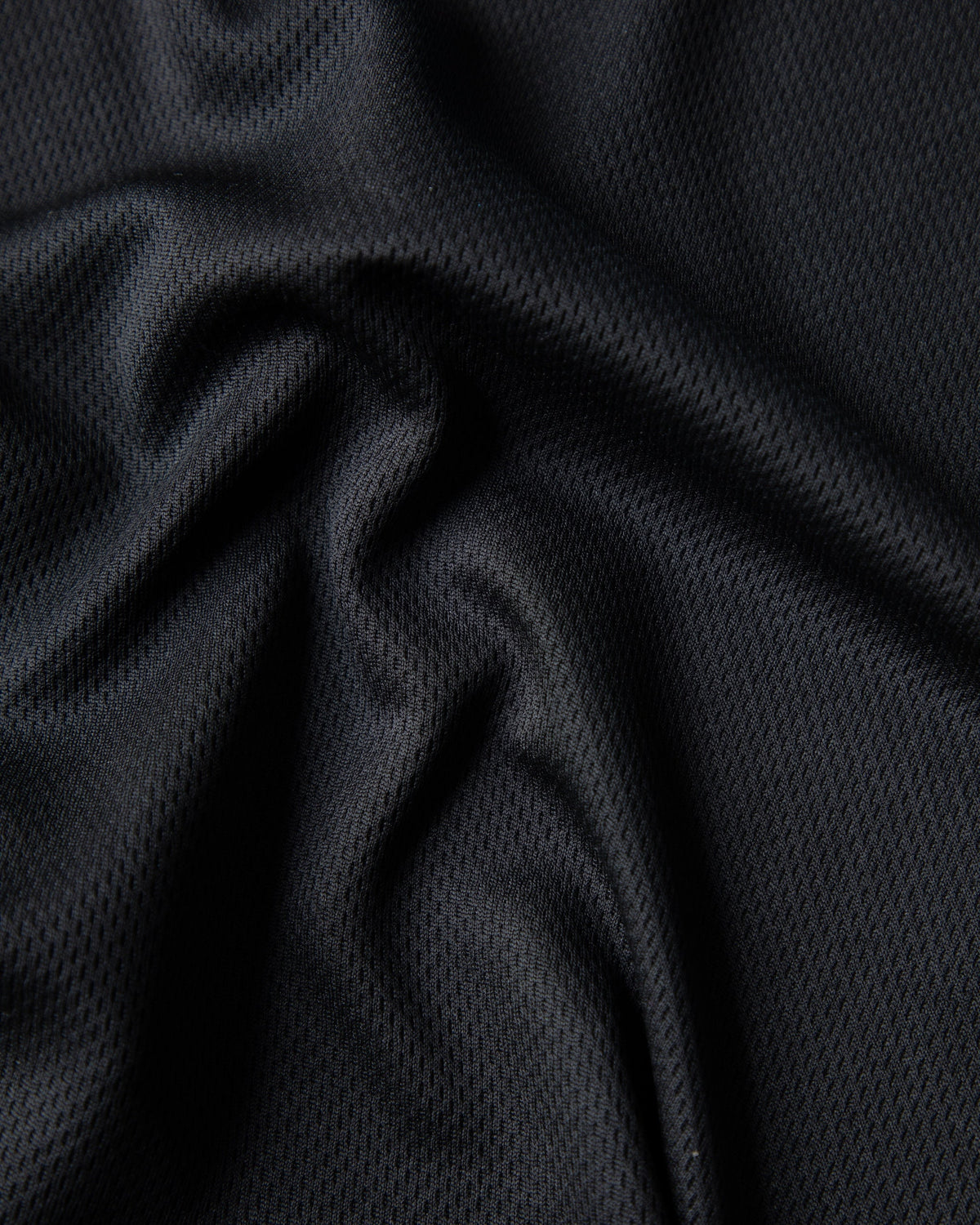 Alan Walker Unity Force Tribe Jersey fabric macro, soft folds of the breathable black mesh knit material