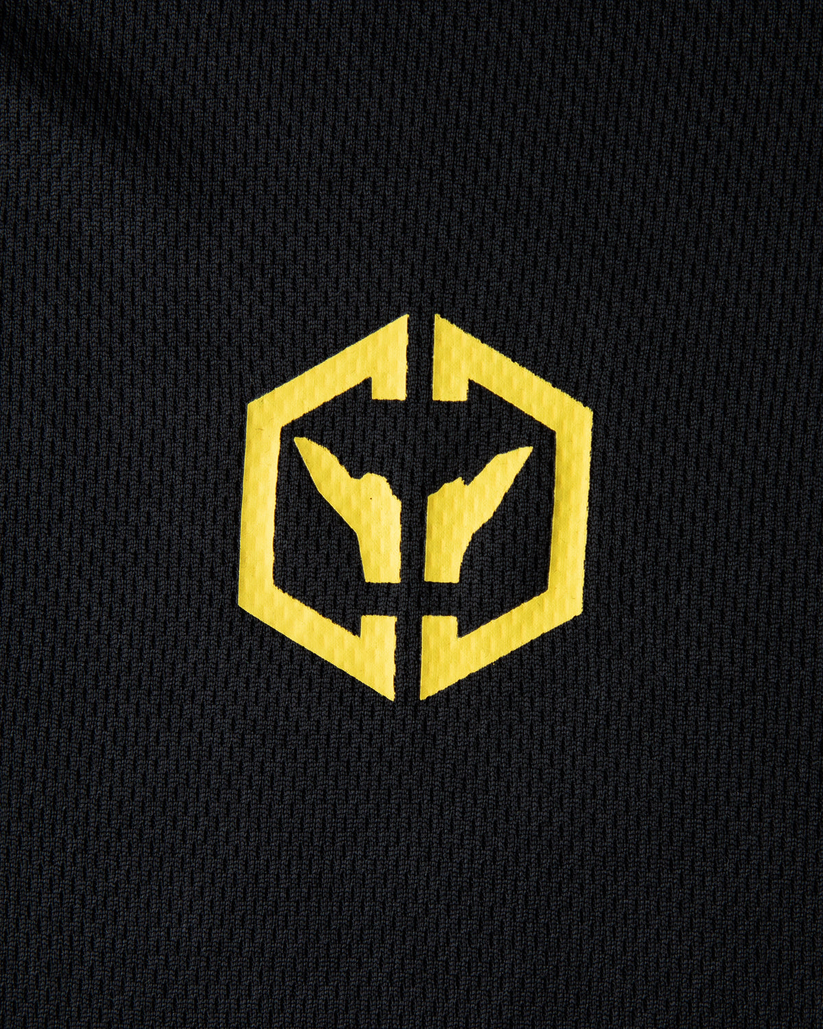 Alan Walker CheckPoint One Tribe Jersey crest close-up, yellow hexagon tribe emblem on black mesh fabric