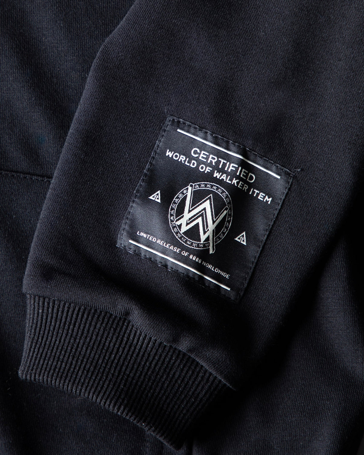 Alan Walker Monster Core Kids Zip Hoodie sleeve close-up with the woven World of Walker label above a ribbed cuff
