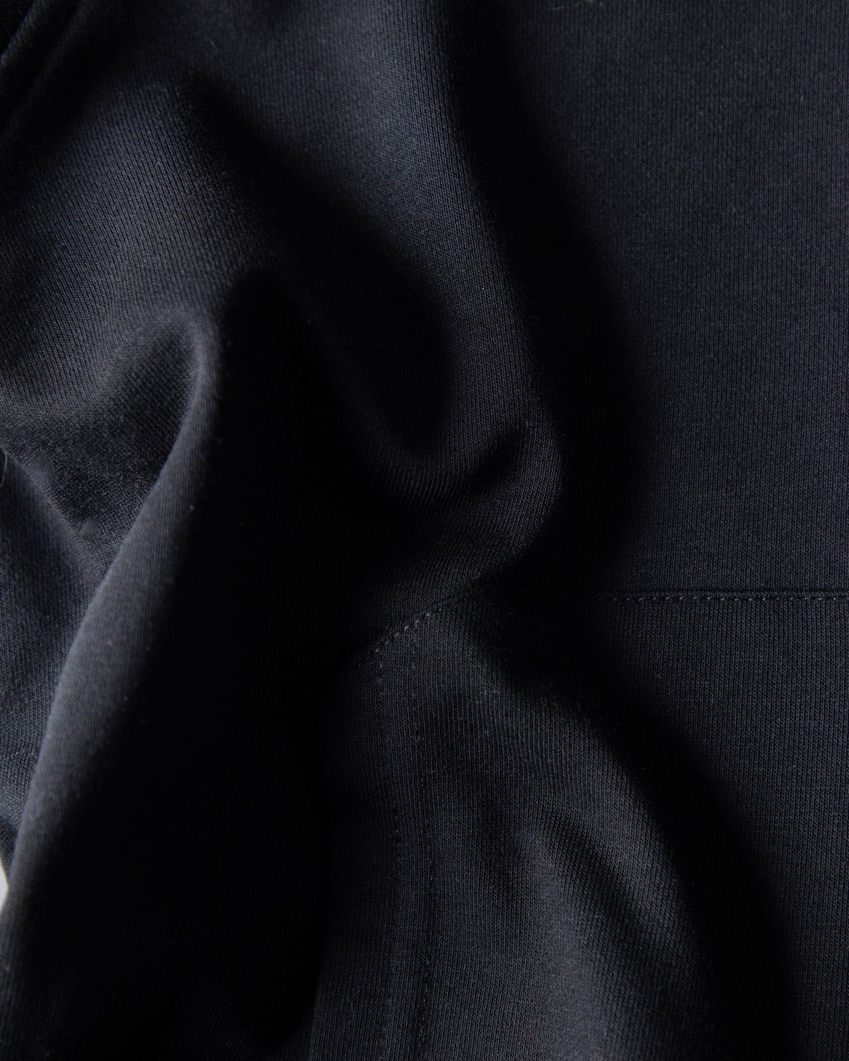 Alan Walker Monster Core Kids Zip Hoodie fabric close-up showing the soft black brushed fleece and pocket stitching