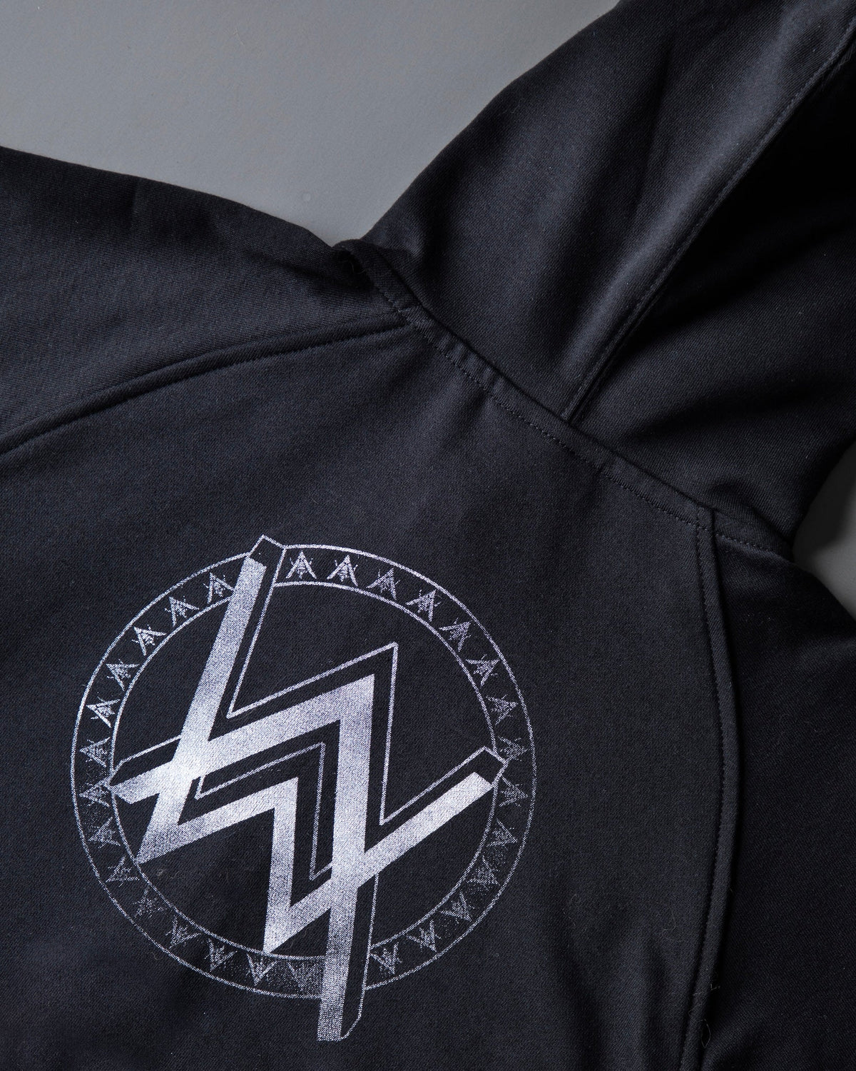 Alan Walker Monster Core Kids Zip Hoodie hood and shoulder detail with the silver AW runic circle logo on black fleece