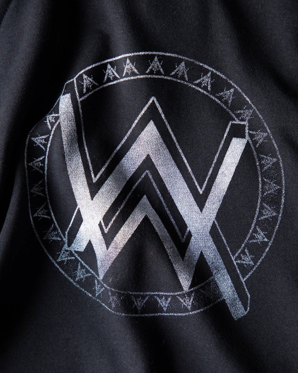 Alan Walker Monster Core Kids Zip Hoodie back print close-up, metallic silver AW logo ringed by runic marks on black