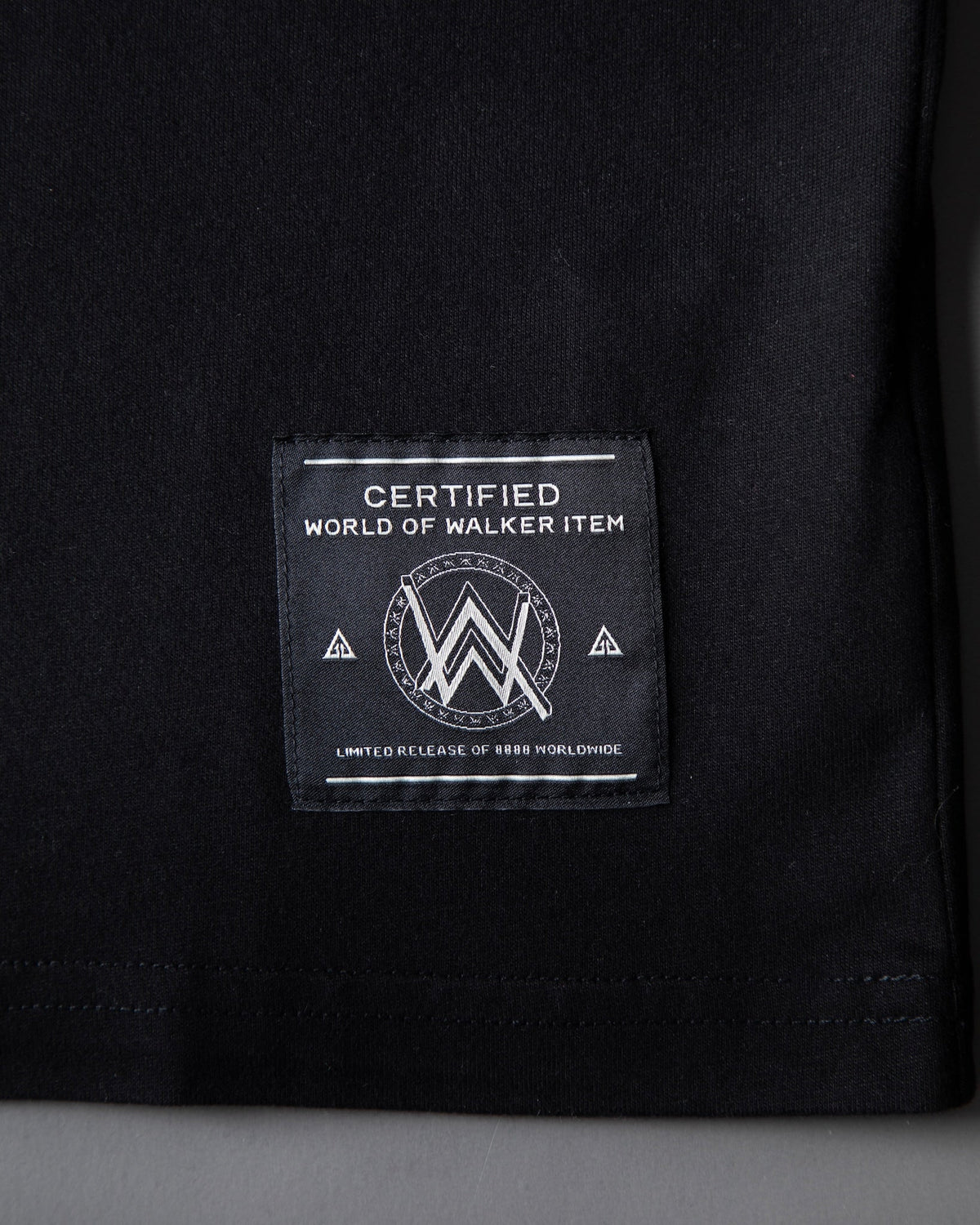 Alan Walker Monster Core T-Shirt hem close-up with the World of Walker item woven label on black cotton