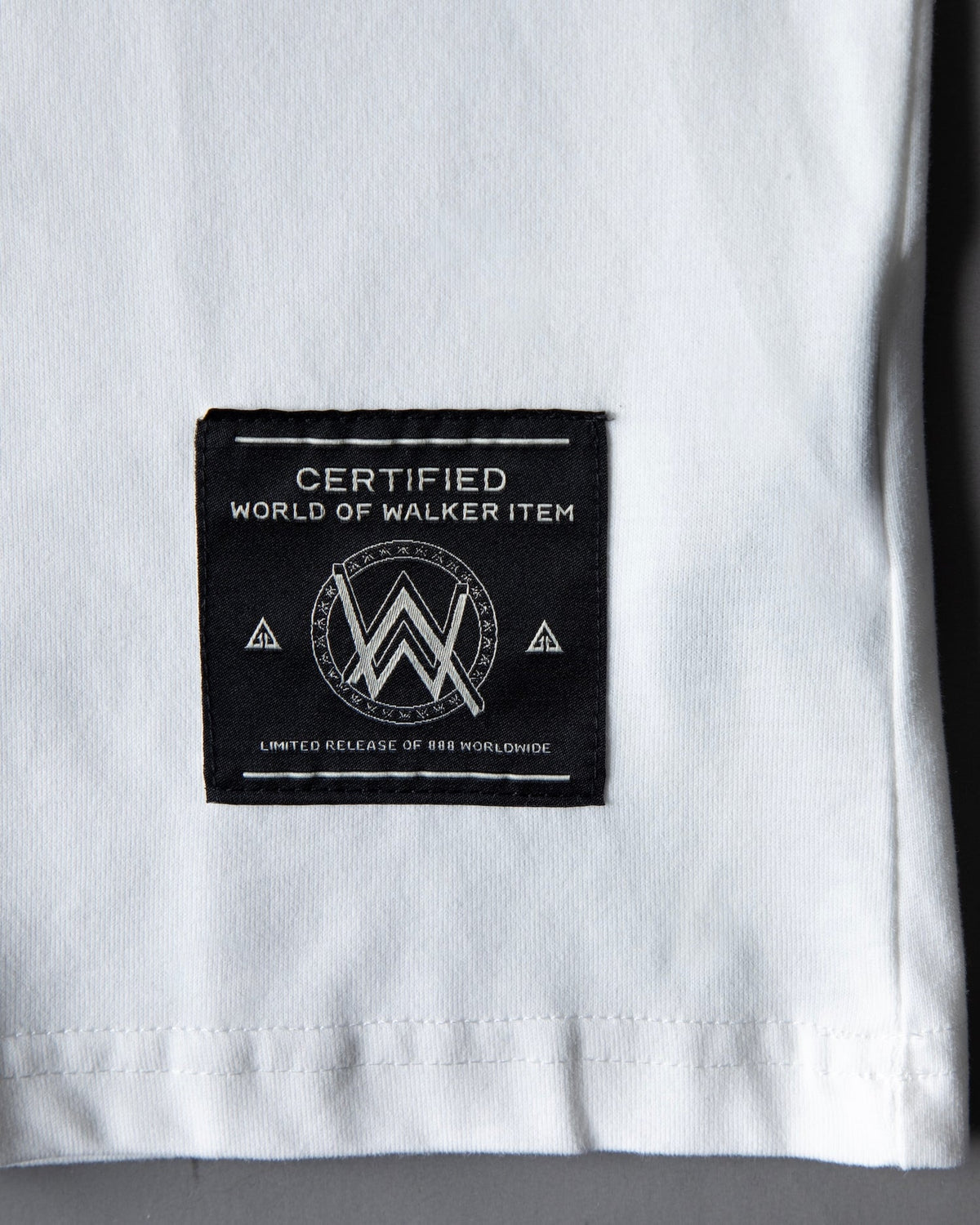 Hem detail of the Faded Play T-shirt showing the black woven woven World of Walker label