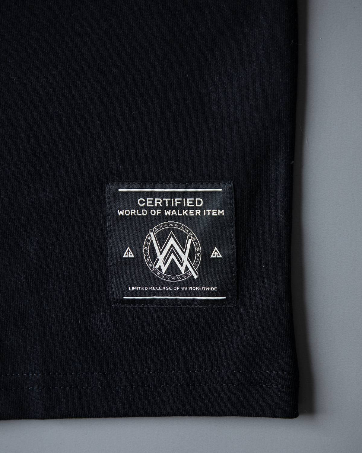 Alan Walker Tired 0 Tee hem detail, World of Walker woven label on the folded black cotton tee