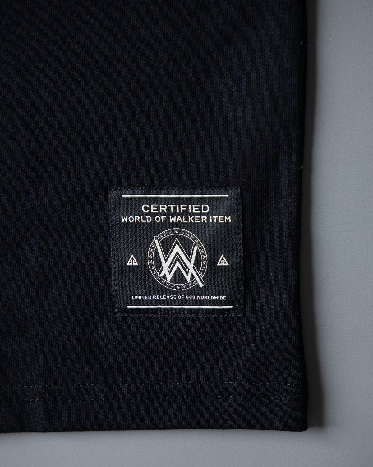 Alan Walker Tired Unity T-Shirt folded flat, World of Walker hem label on black cotton
