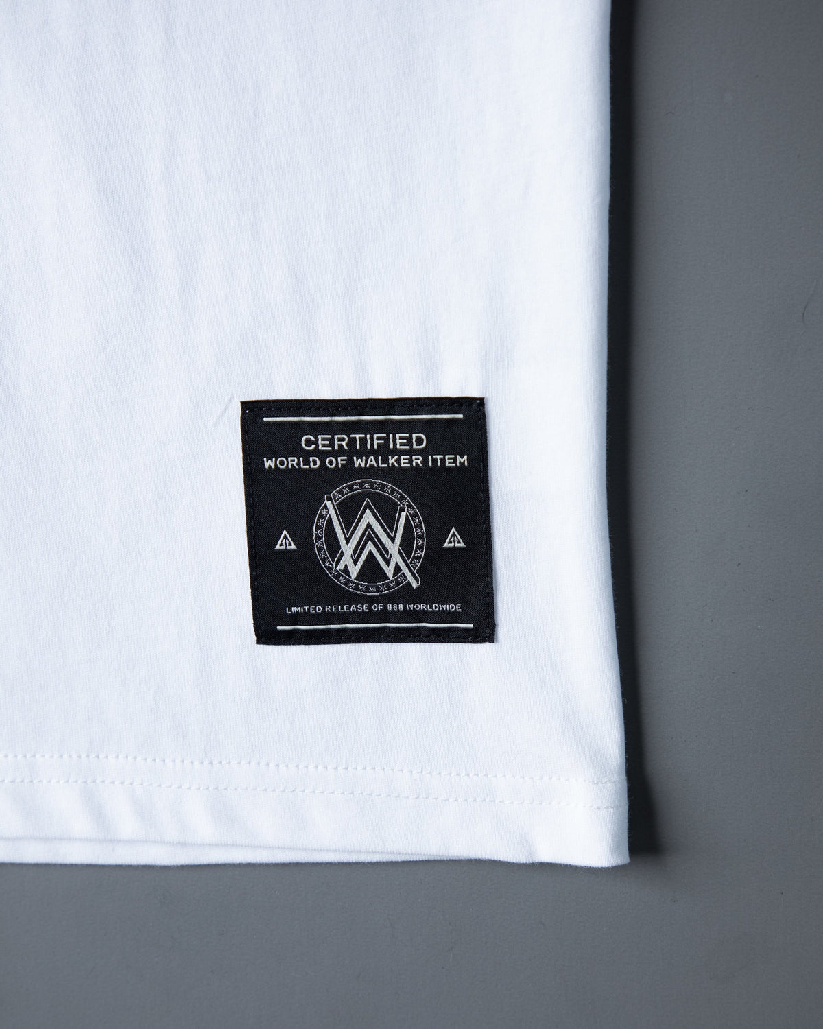 Alan Walker End of the World T-Shirt hem detail, black woven World of Walker label on white cotton