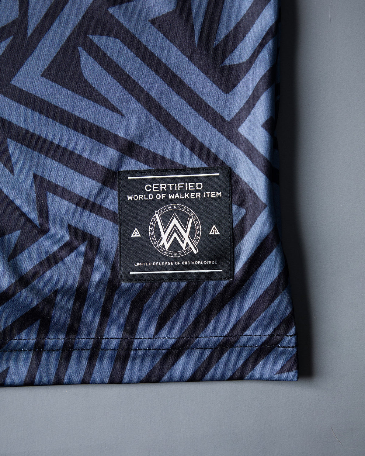 Alan Walker Gaming Jersey hem detail, woven World of Walker label stitched on the navy blue maze mesh