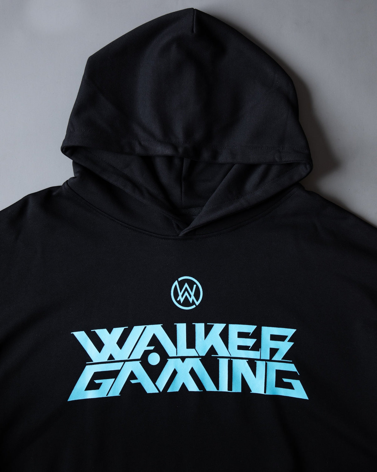 Alan Walker Gaming Hoodie front close-up, black hood above the blue AW logo and Walker Gaming wordmark