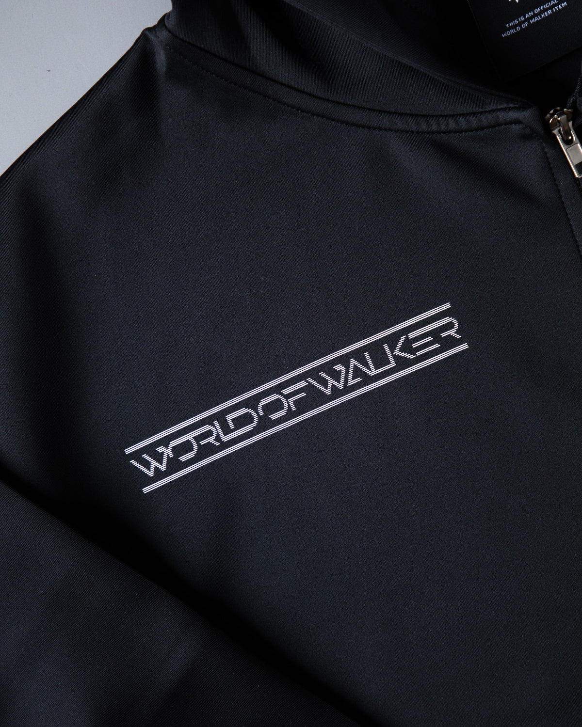 Alan Walker World of Walker Skyline Zip Hoodie chest close-up, diagonal white World of Walker skyline tape print