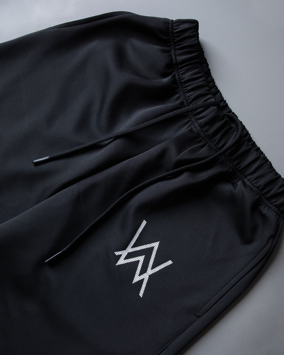 Alan Walker World of Walker Skyline Sweatpants folded detail, white striped AW logo beside the zip side pocket