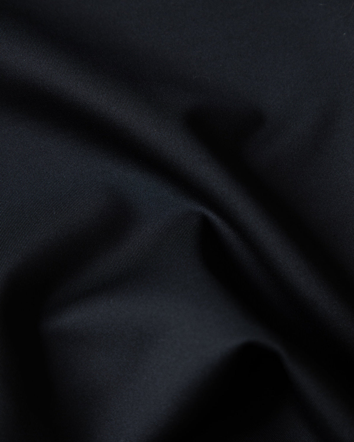 Alan Walker World of Walker Skyline Sweatpants fabric macro showing the smooth black twill weave and drape