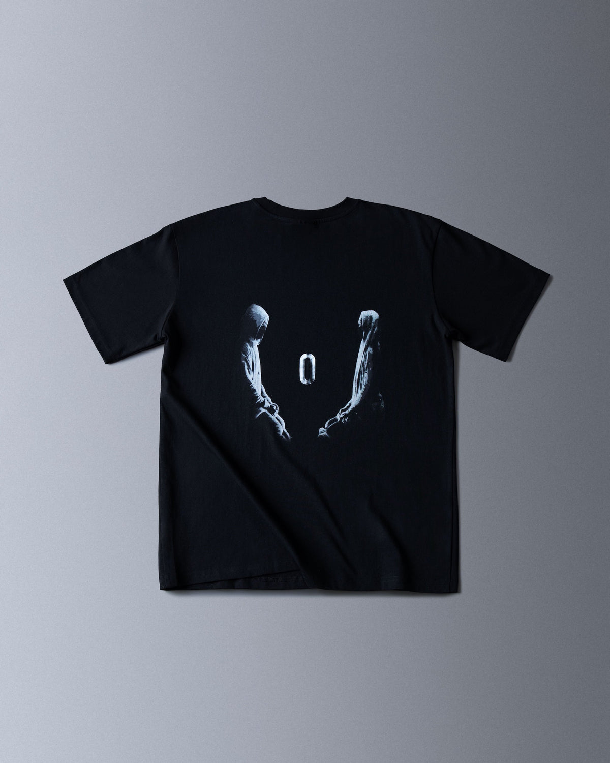 Alan Walker Tired 0 Tee in black, back flat lay with the two hooded figures and floating zero graphic