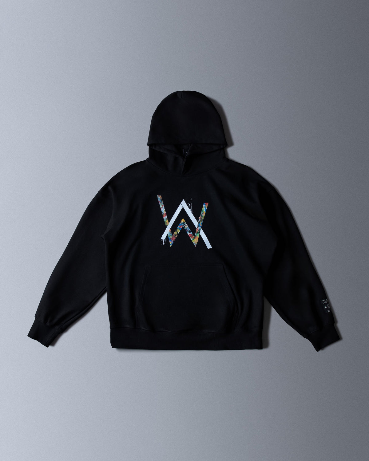 Alan Walker Tired Unity Hoodie front flat lay, black fleece with the multicoloured AW logo on the chest