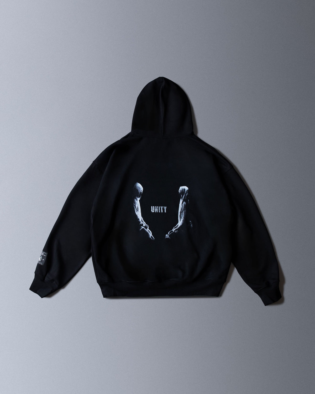 Alan Walker Tired Unity Hoodie in black, back flat lay with the Unity figures and reaching hands print