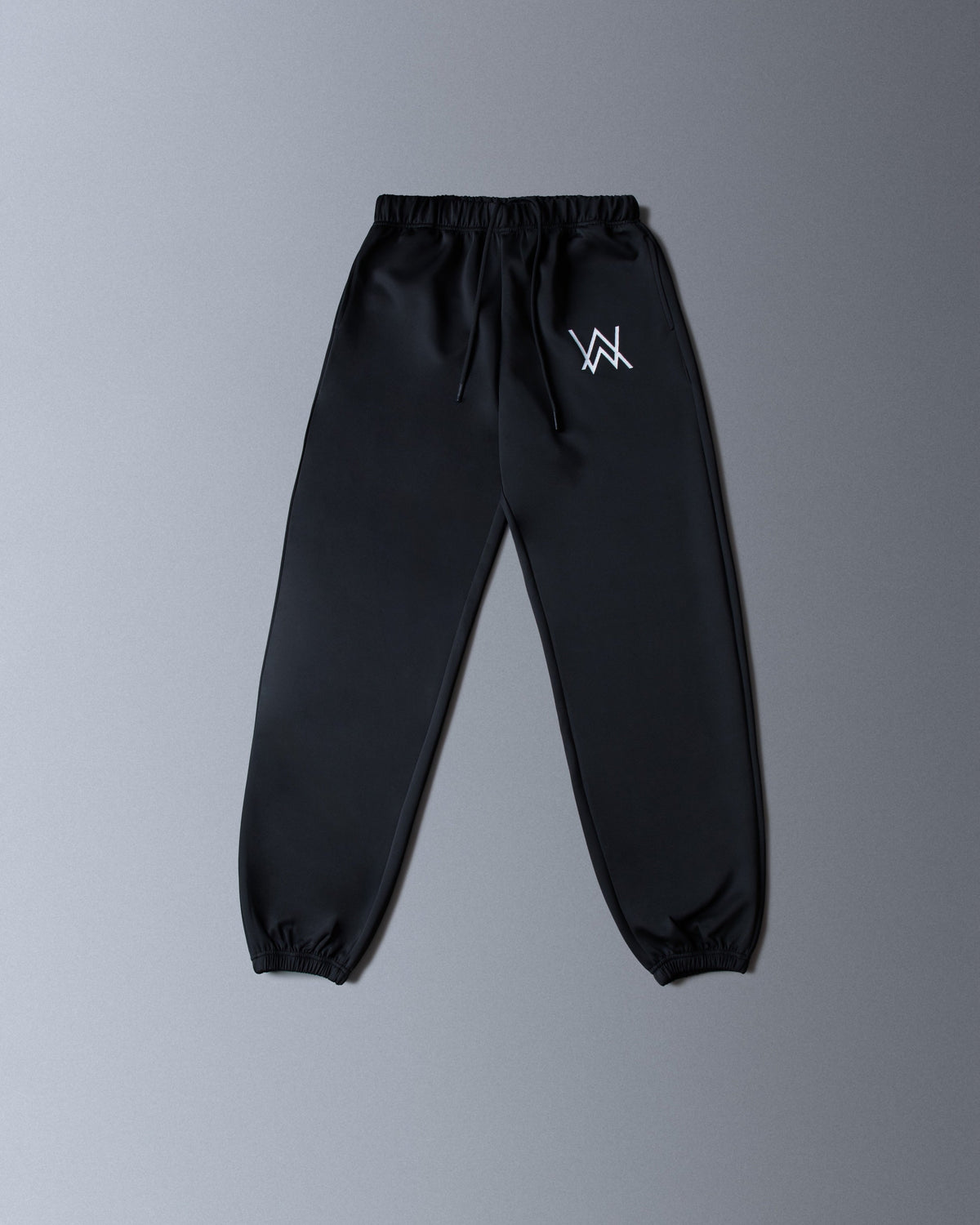 Alan Walker World of Walker Skyline Sweatpants black flat lay, tapered joggers with small white AW hip logo