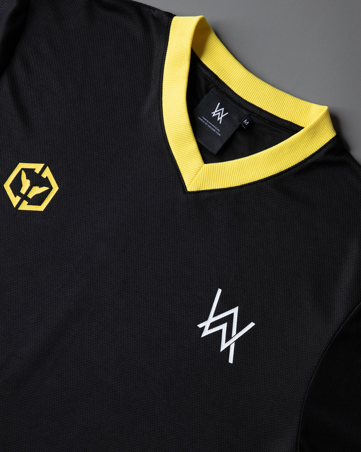 Alan Walker CheckPoint One Tribe Jersey chest detail, yellow hex crest beside a white AW glyph on black mesh