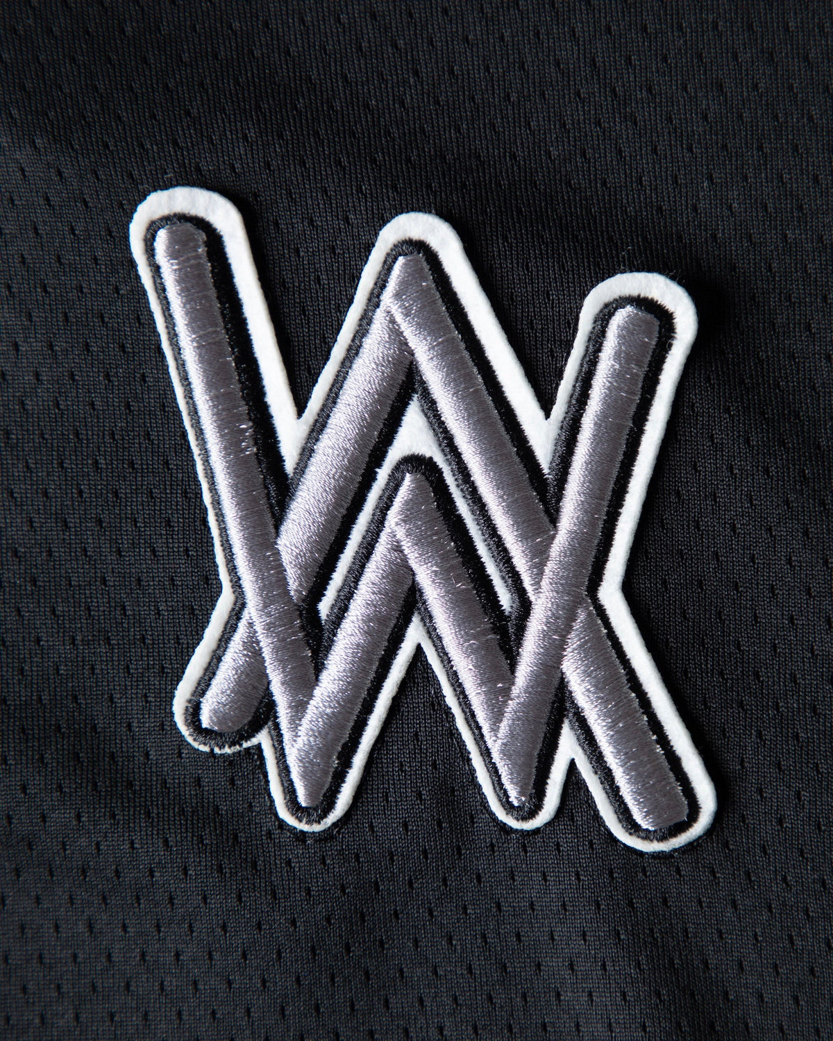 Alan Walker 0 Hockey Jersey chest patch close-up, embroidered grey AW logo outlined in white on mesh