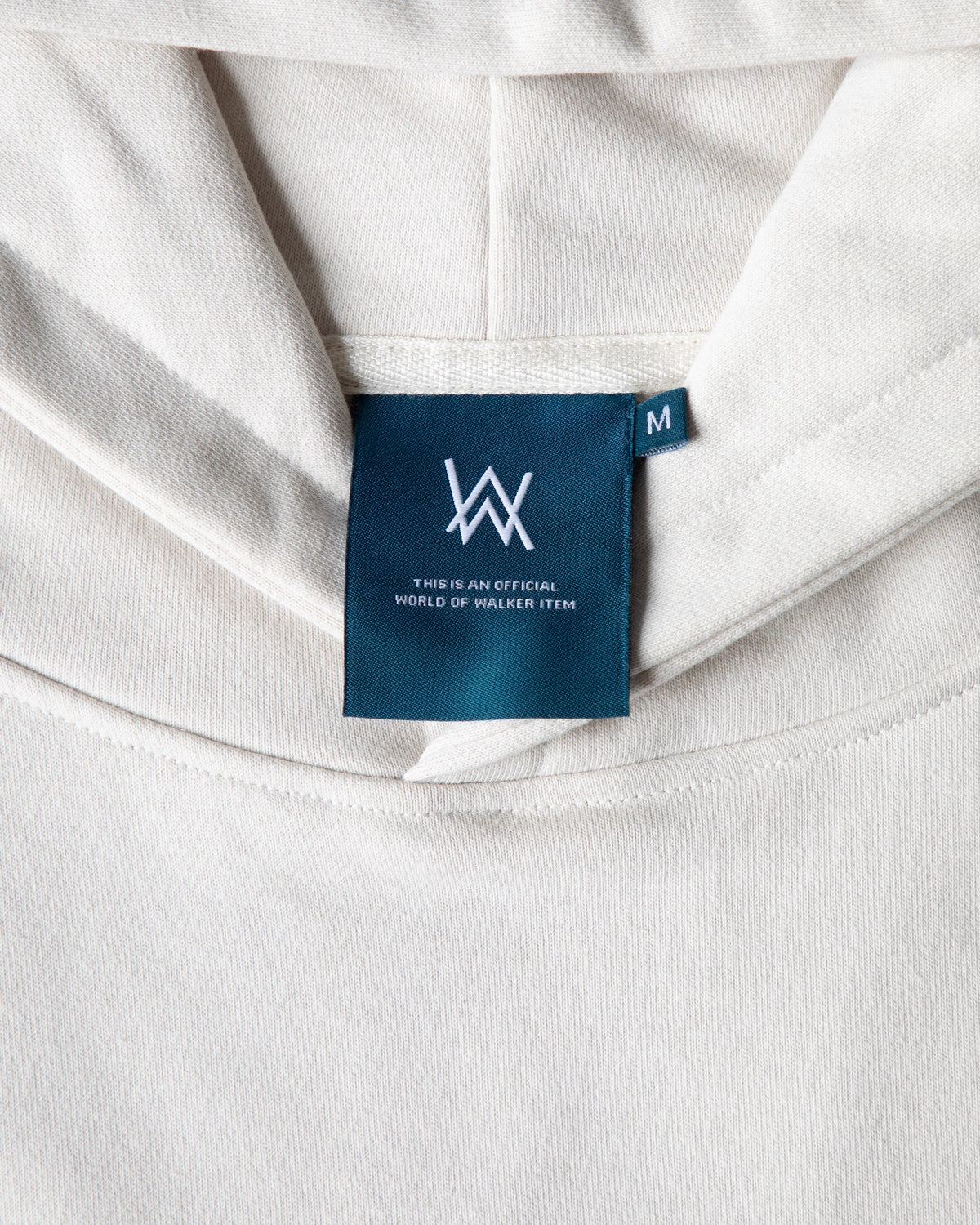 Alan Walker Encyclopedia Hoodie neck detail, teal World of Walker label stitched inside the off white hood