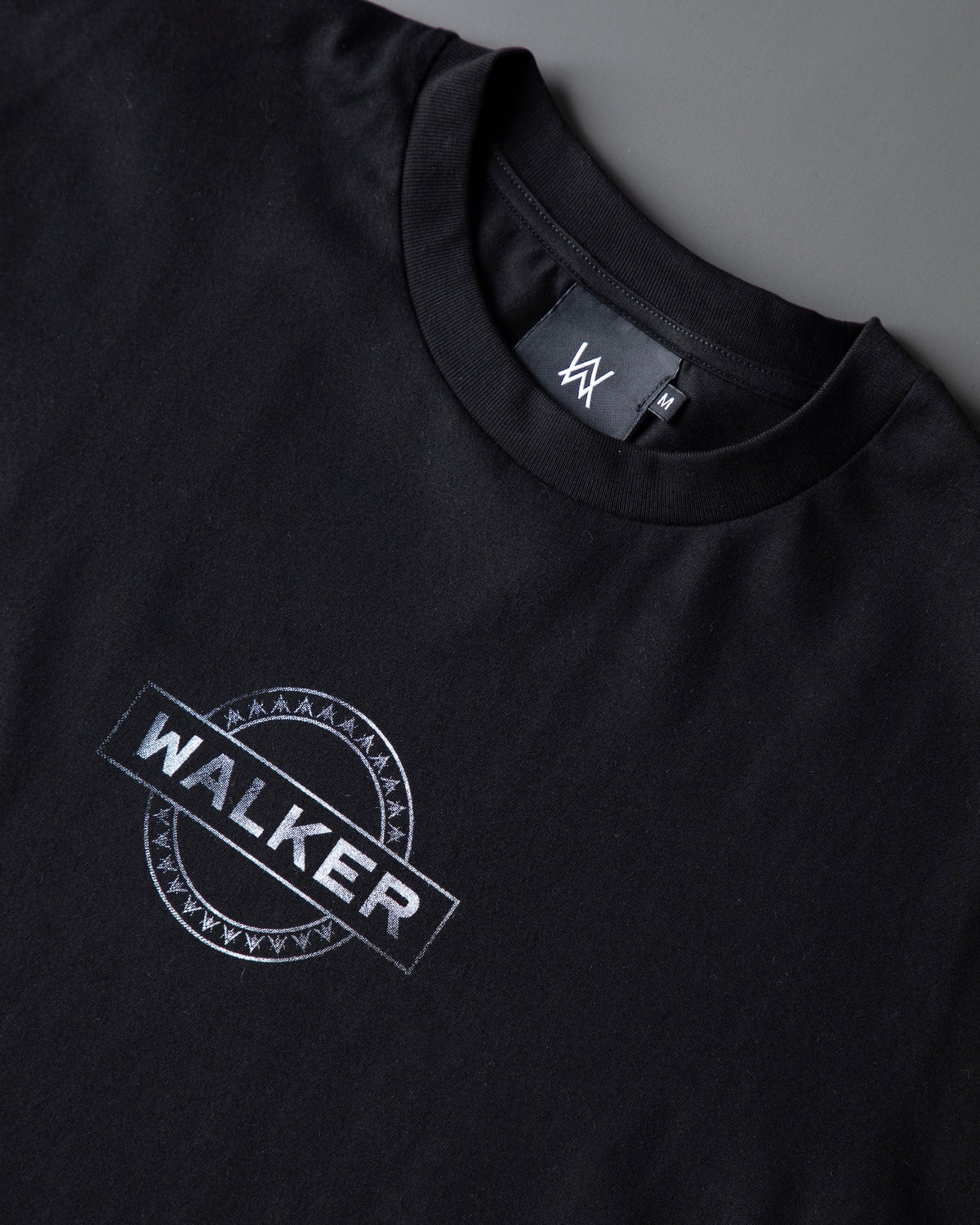 Alan Walker Monster Core Longsleeve chest print close-up, tilted silver WALKER circle stamp under a ribbed crew neck