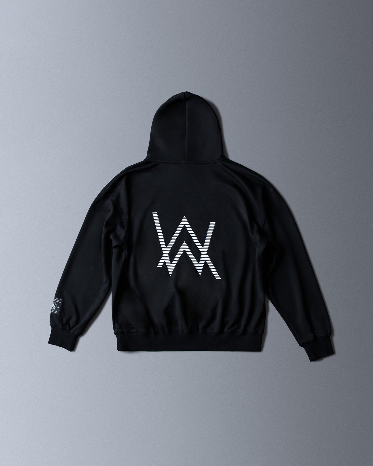 Alan Walker World of Walker Skyline Hoodie back flat lay, large striped white AW logo centred on black fleece