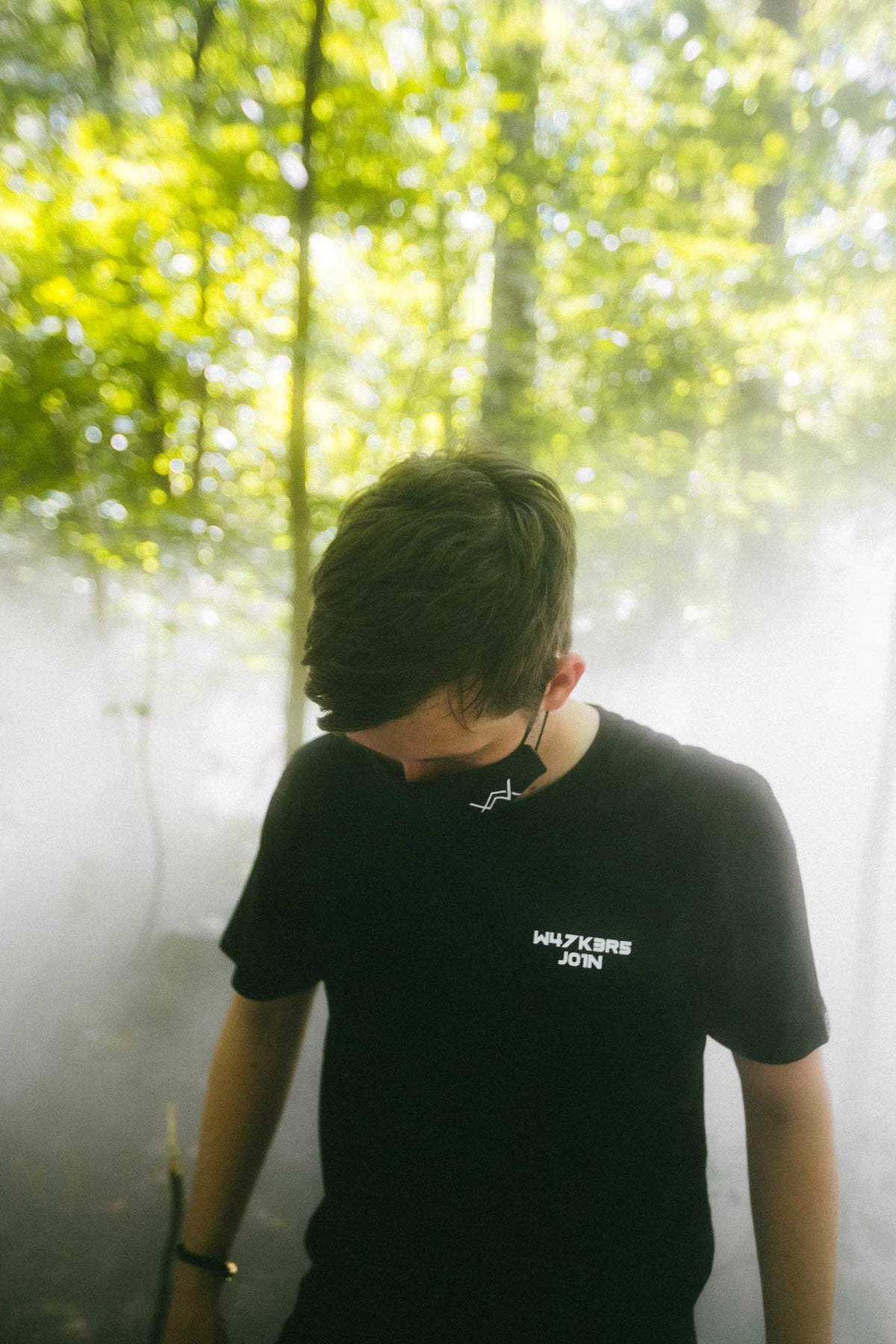 Alan Walker Core Logo T-Shirt worn in a misty forest, black tee with the white W47K3R5 J01N chest print