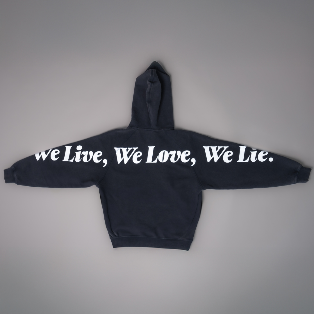 Alan Walker Lyrics Hoodie back flat lay, We Live We Love We Lie in white script across the back and sleeves