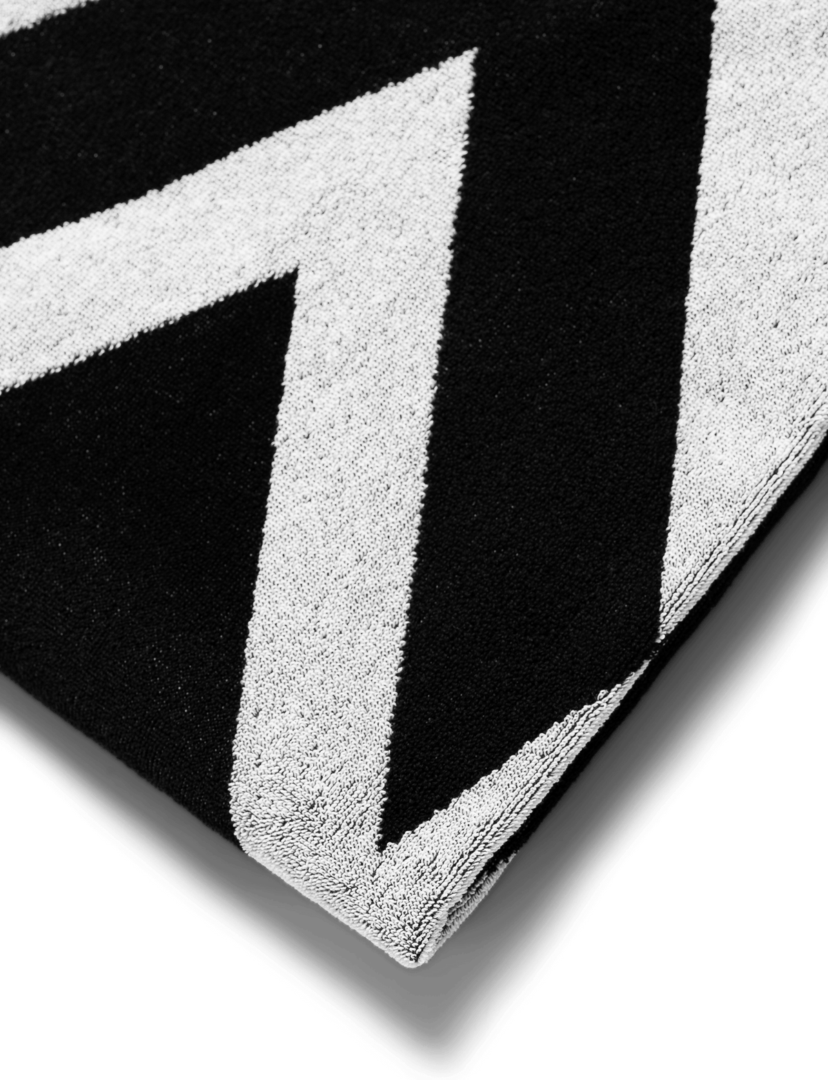 Alan Walker Logo Towel corner detail, black terry cloth lifted to show the crisp white AW logo print
