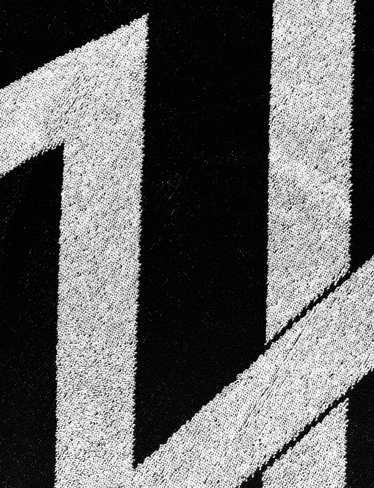 Alan Walker Logo Towel macro close-up, woven white AW logo standing out against the black looped pile