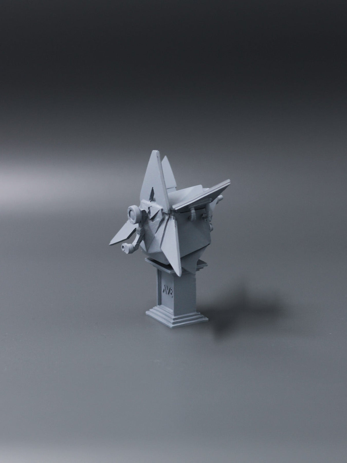Alan Walker AV8 Figurine at an angle, grey winged AW statue on a stepped plinth against a dark backdrop