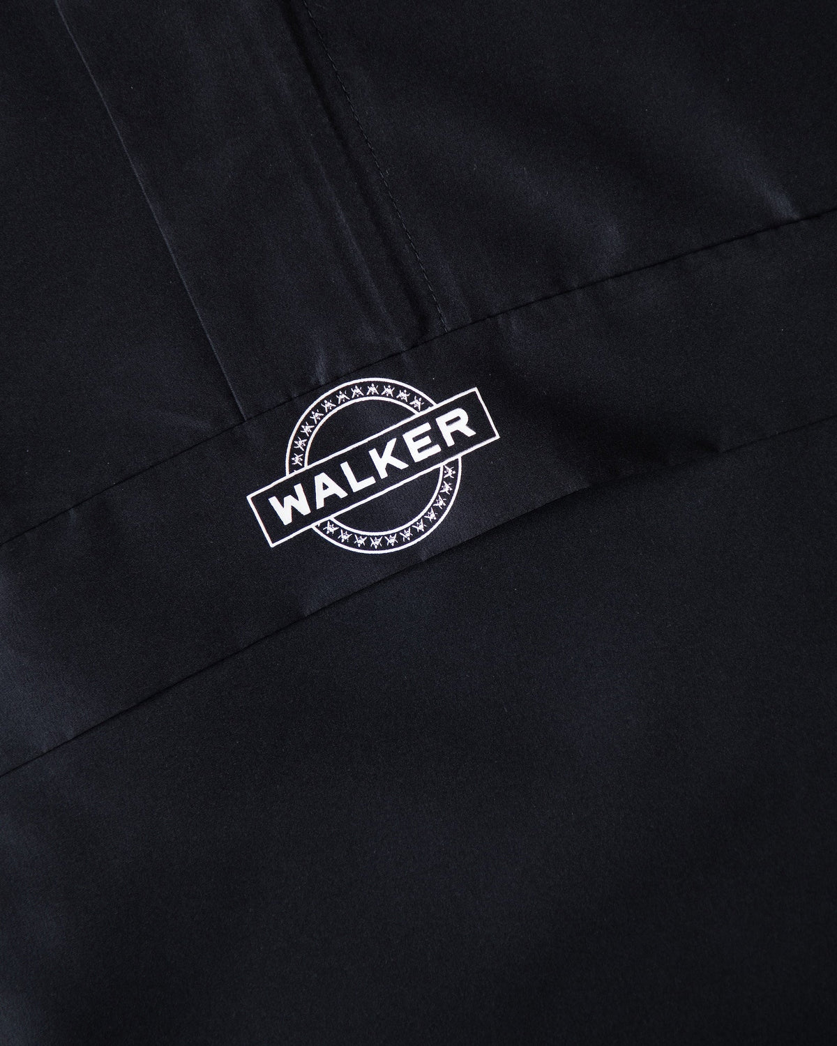 Alan Walker Core LV1 Windbreaker chest pocket detail, white Walker stamp logo beside a hidden zip