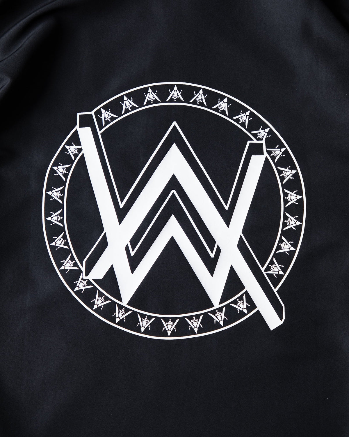 Alan Walker Core LV1 Windbreaker back crest close-up, white AW logo ringed by runic marks on black shell