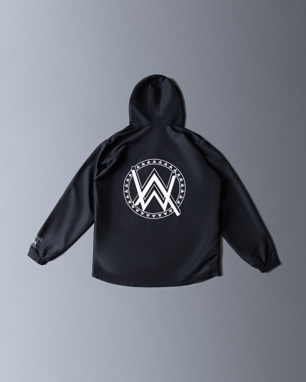 Alan Walker Core LV1 Windbreaker back flat lay, black hooded shell with a white circular AW crest print