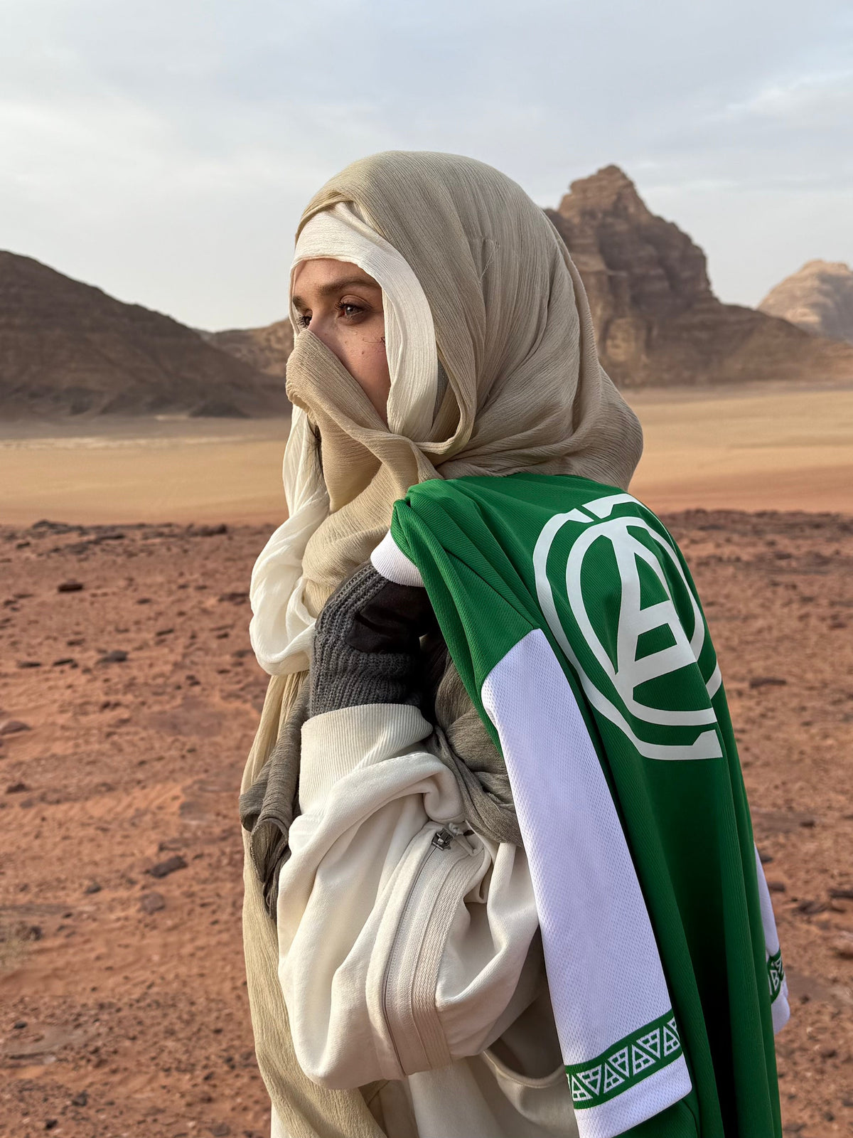 Alan Walker Creator Circle Tribe Jersey in a desert lifestyle shot, green sleeve with the white circular crest