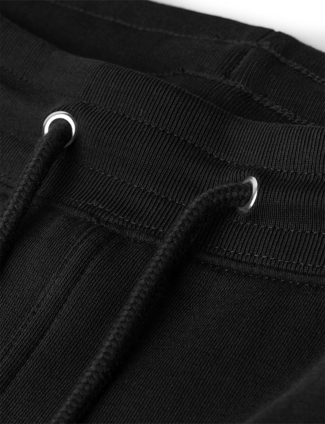 Alan Walker Core Drone Sweatpants waistband detail, black drawcord through metal eyelets on ribbed fleece