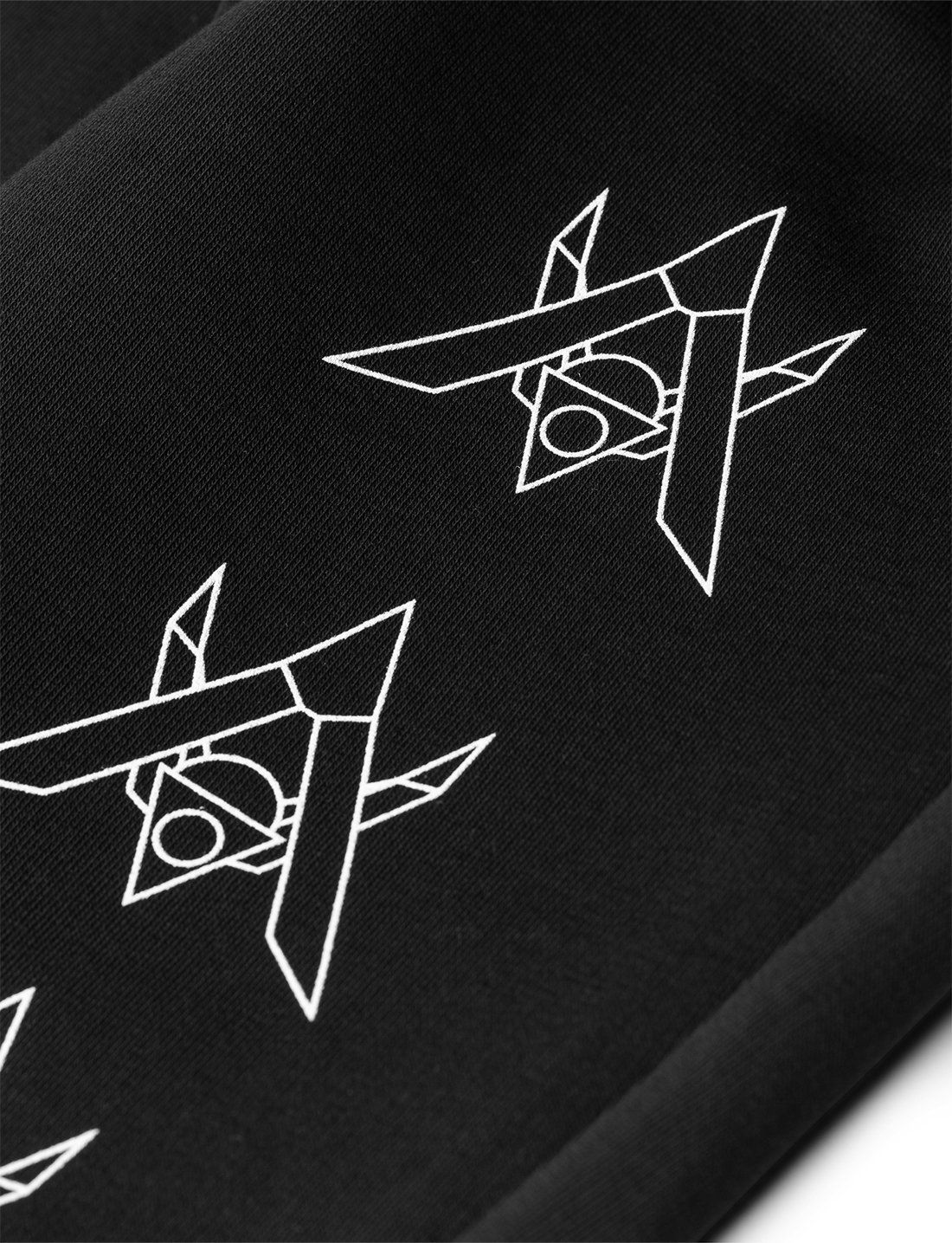 Alan Walker Core Drone Sweatpants leg print close-up, white outlined drone graphics stacked on black fabric