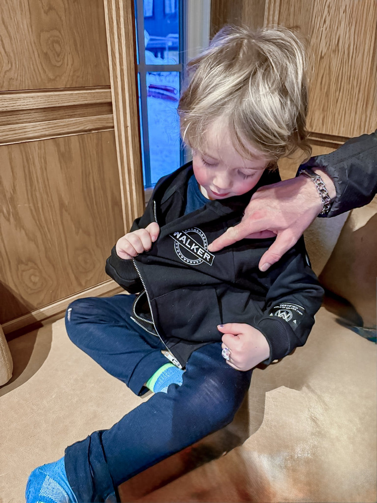 Alan Walker Monster Core Kids Zip Hoodie worn by a young boy indoors, black zip-up with Walker crest logo