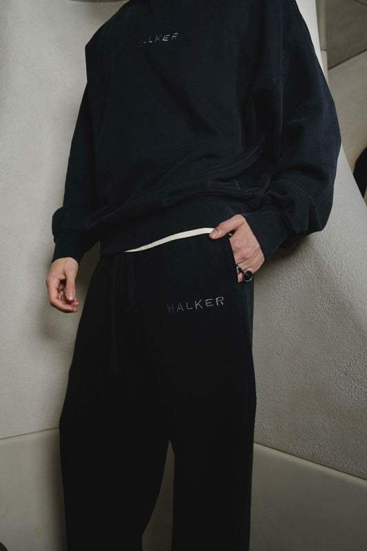 Alan Walker Core Sweatpants close-up worn with a black hoodie, tonal Walker branding at the pocket