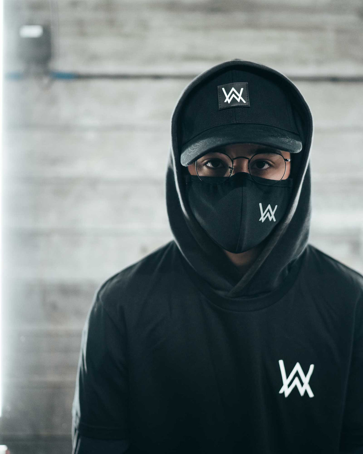 Alan Walker Core W47K3R5 J01N T-Shirt worn under a hood and AW mask, small white logo on the chest
