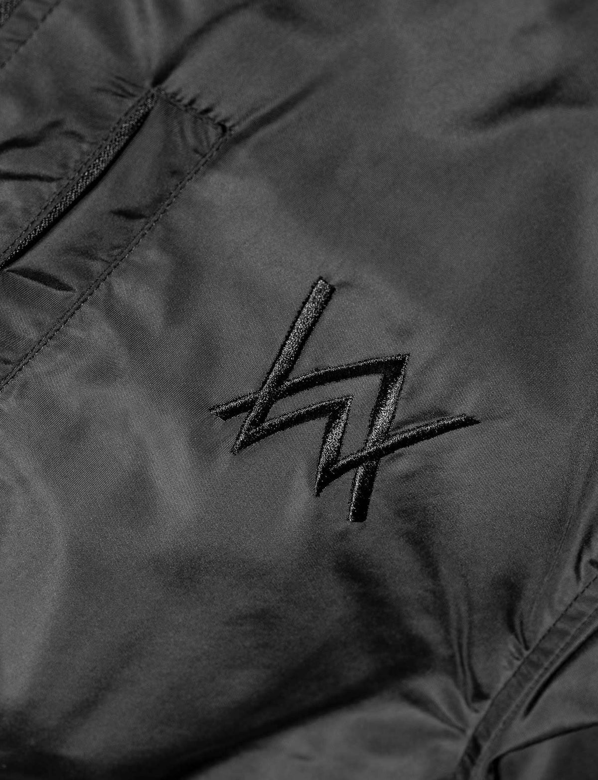 Alan Walker Walkerverse Bomber Jacket chest detail, tonal black AW logo embroidered on the nylon shell