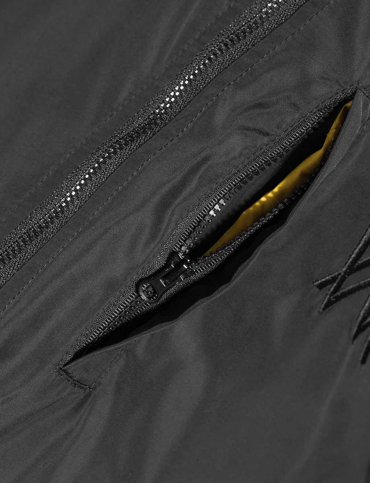 Alan Walker Walkerverse Bomber Jacket sleeve zip pocket unzipped to reveal the yellow lining inside