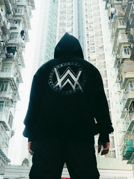 Alan Walker Monster Core Hoodie worn back view on a city street, oversized black fleece with large AW logo print